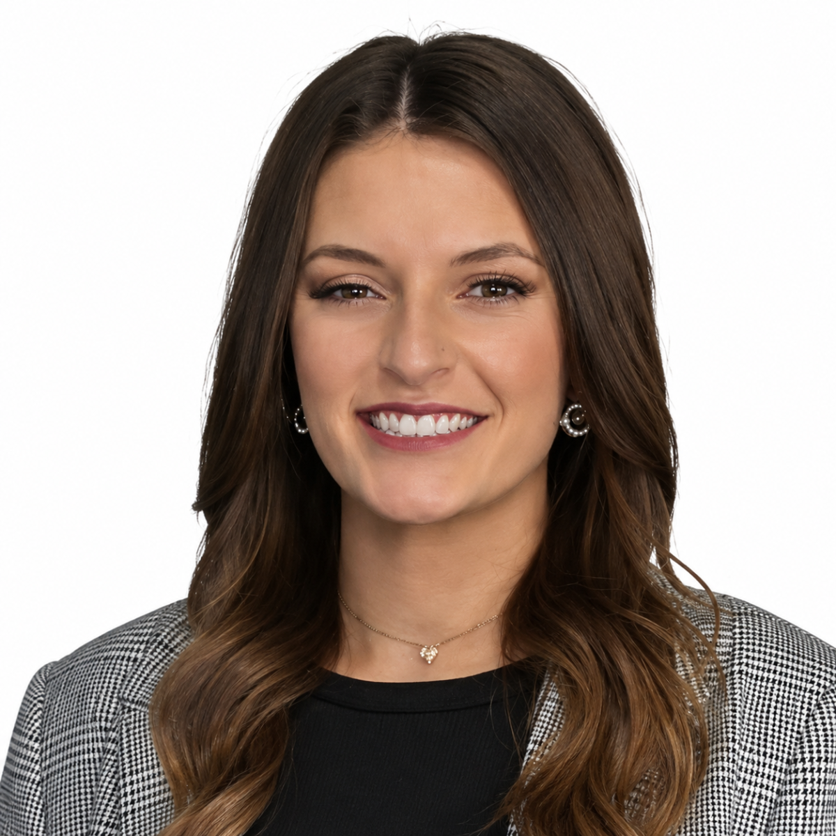 A woman with long brown hair, Wills & Trusts Attorney, wearing a plaid blazer, black top, and earrings, smiling in front of a white background.